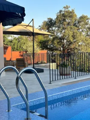 a swimming pool with two chairs and an umbrella at Villa Žukovica in Petrovac na Moru