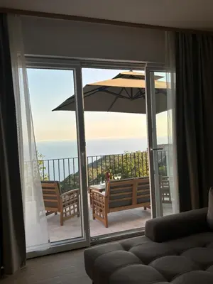 a living room with a patio with an umbrella at Villa Žukovica in Petrovac na Moru