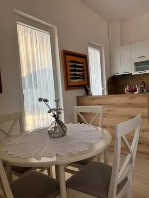 a dining room table with a vase of flowers on it at Villa Žukovica in Petrovac na Moru