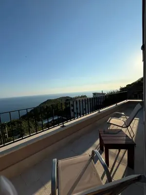 two chairs and a table on a balcony overlooking the ocean at Villa Žukovica in Petrovac na Moru