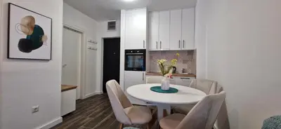 a kitchen and dining room with a white table and chairs at Zira2 in Kotor