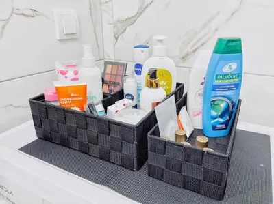 a black basket with products on a bathroom counter at Apartman DE LUX RADIVOJEVIĆ in Sutomore