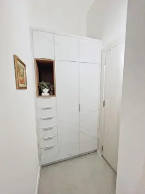 a white closet with white cabinets in a room at Apartman DE LUX RADIVOJEVIĆ in Sutomore