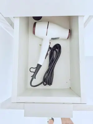 a white hair dryer in a white cabinet at Apartman DE LUX RADIVOJEVIĆ in Sutomore