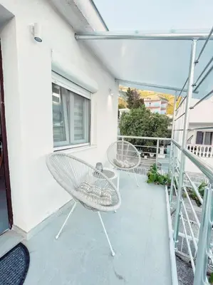 a patio with two chairs on a balcony at Apartman DE LUX RADIVOJEVIĆ in Sutomore