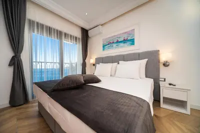a bedroom with a large bed and a large window at Exclusive Hotel in Budva