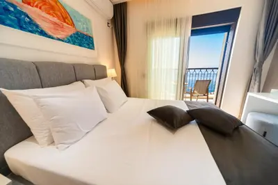 a bedroom with a white bed with a large window at Exclusive Hotel in Budva