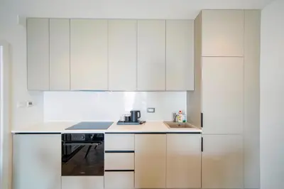 a white kitchen with white cabinets and a sink at Exclusive Hotel in Budva