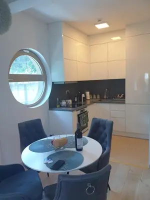 a kitchen with a table and chairs in a room at AVAbys apartman in Pržno