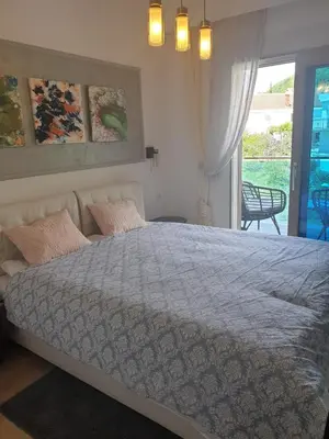 a bedroom with a large bed and a window at AVAbys apartman in Pržno