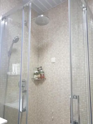 a shower with a glass door in a bathroom at AVAbys apartman in Pržno