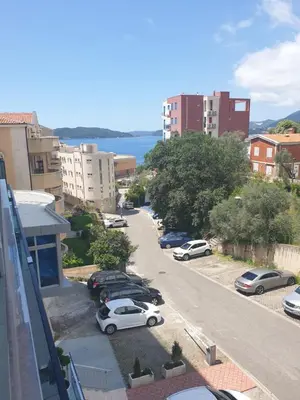 a city street with cars parked in a parking lot at AVAbys apartman in Pržno