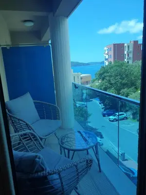 a balcony with a couch and a table and a view at AVAbys apartman in Pržno