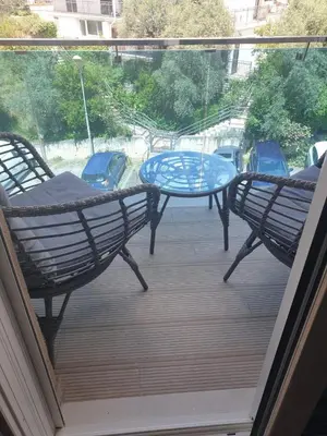 a patio with two chairs and a table on a balcony at AVAbys apartman in Pržno