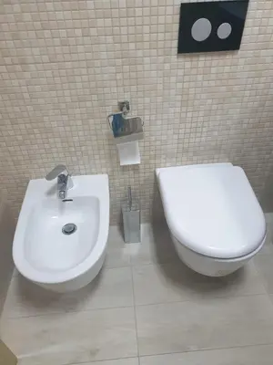 a bathroom with a white toilet and a sink at AVAbys apartman in Pržno