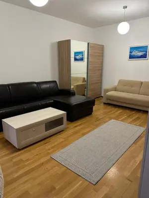 a living room with a black leather couch and a table at Light Bar Apartment in Bar