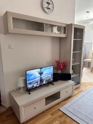 a living room with a flat screen tv on a cabinet at Light Bar Apartment in Bar