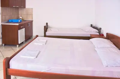 two beds in a small room with a kitchen at Vera Apartments in Budva