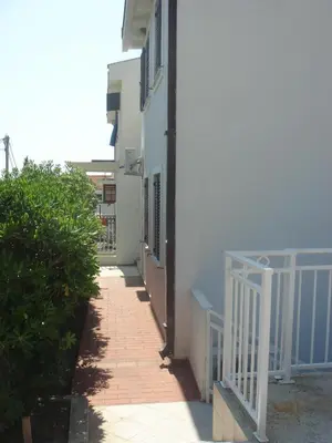 a walkway next to a white building with a white railing at Vera Apartments in Budva
