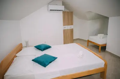 a large white bed with green pillows in a room at Lovely apartment Moki near the center in Kotor