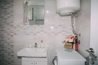 a bathroom with a sink and a toilet and a mirror at Lovely apartment Moki near the center in Kotor