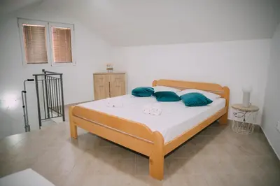 a bedroom with a bed with blue pillows at Lovely apartment Moki near the center in Kotor