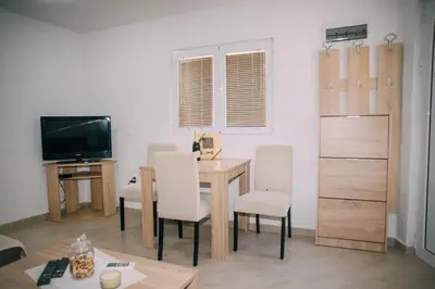 a living room with a table and chairs and a television at Lovely apartment Moki near the center in Kotor