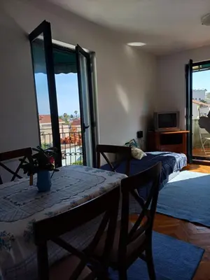 a bedroom with a table and chairs and a balcony at Sea breeze Budva in Budva