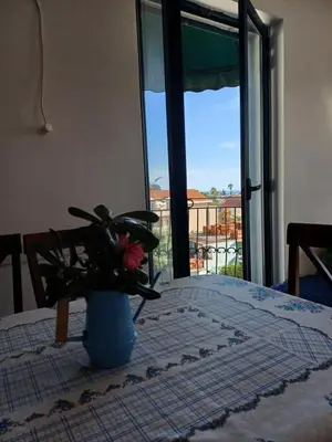a vase with a flower on a table with a window at Sea breeze Budva in Budva