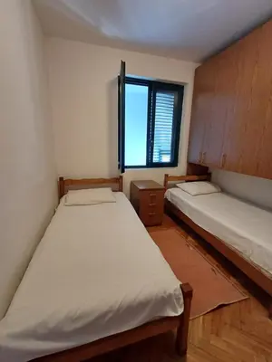 two beds in a small room with a window at Sea breeze Budva in Budva
