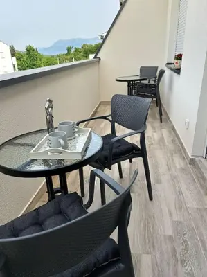 a balcony with two tables and chairs and a table at Zira in Kotor