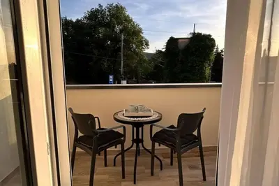 a balcony with a table and chairs and a window at Zira in Kotor