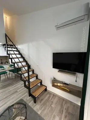 a living room with a staircase and a flat screen tv at Zira in Kotor