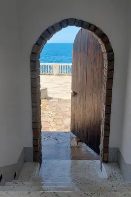 an archway with a door leading to the ocean at Sea Cliff Villa in Bar