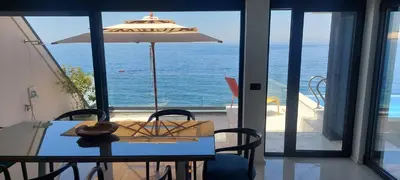 a table with an umbrella and a view of the ocean at Sea Cliff Villa in Bar