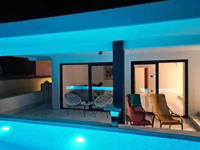 a swimming pool with two chairs and a living room at Sea Cliff Villa in Bar