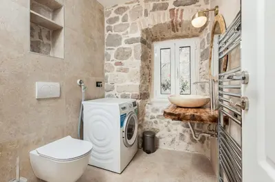 a bathroom with a washing machine and a sink at Seaside Stone House - Bella Vista in Kotor