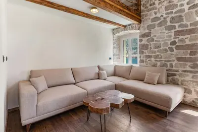 a living room with a couch and two tables at Seaside Stone House - Bella Vista in Kotor
