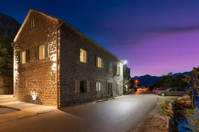 a brick building with a car parked on a street at Seaside Stone House - Bella Vista in Kotor