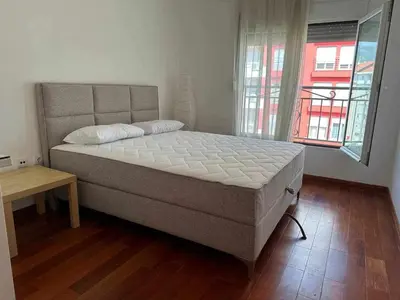 a bedroom with a bed and a table and windows at Sasha's apartment in Bar