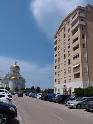 a parking lot with a building and cars parked at Sasha's apartment in Bar