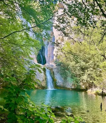 a waterfall in the middle of a river with trees at Chalet Elli's Mountain View in Velje Selo