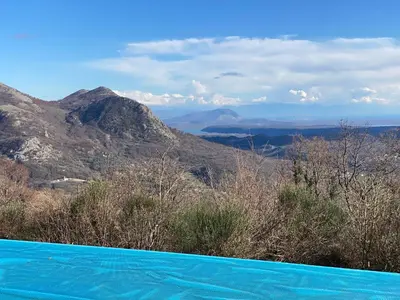 a blue swimming pool with mountains in the background at Chalet Elli's Mountain View in Velje Selo