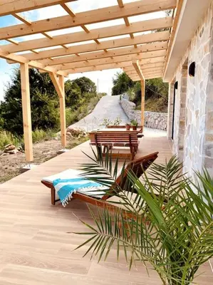 a patio with two benches and a wooden pergola at Chalet Elli's Mountain View in Velje Selo