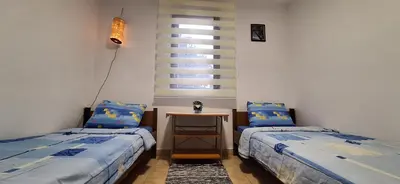 two beds in a room with a table and a window at Apartment Belis Utjeha in Utjeha