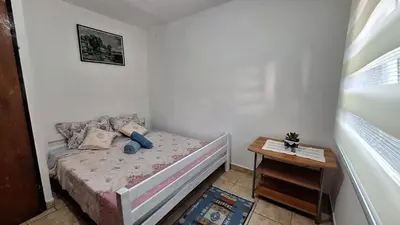 a small bedroom with a bed and a table at Apartment Belis Utjeha in Utjeha
