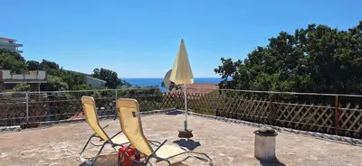 a pair of chairs sitting on a balcony with an umbrella at Apartment Belis Utjeha in Utjeha