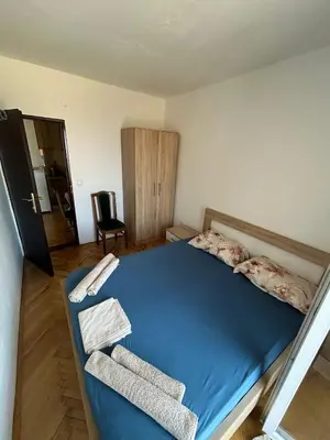 a bedroom with a blue bed and a chair at Oliva apartment in Petrovac na Moru