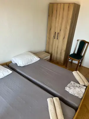 a bedroom with a bed with a chair and a door at Oliva apartment in Petrovac na Moru