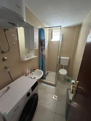 a bathroom with a sink and a washing machine at Oliva apartment in Petrovac na Moru